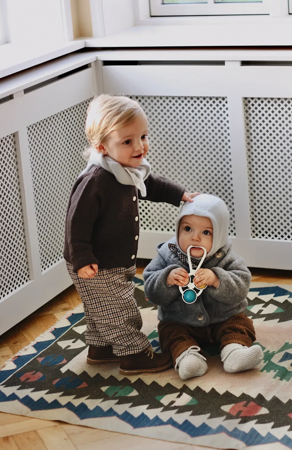 Barn med Atlas-halsduken knuten över en mörk kofta