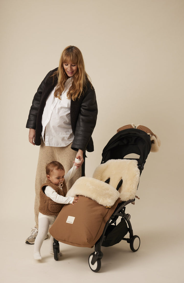 Barnvagn med Puffmuff-åkpåse i Bruno, vuxen och barn bredvid