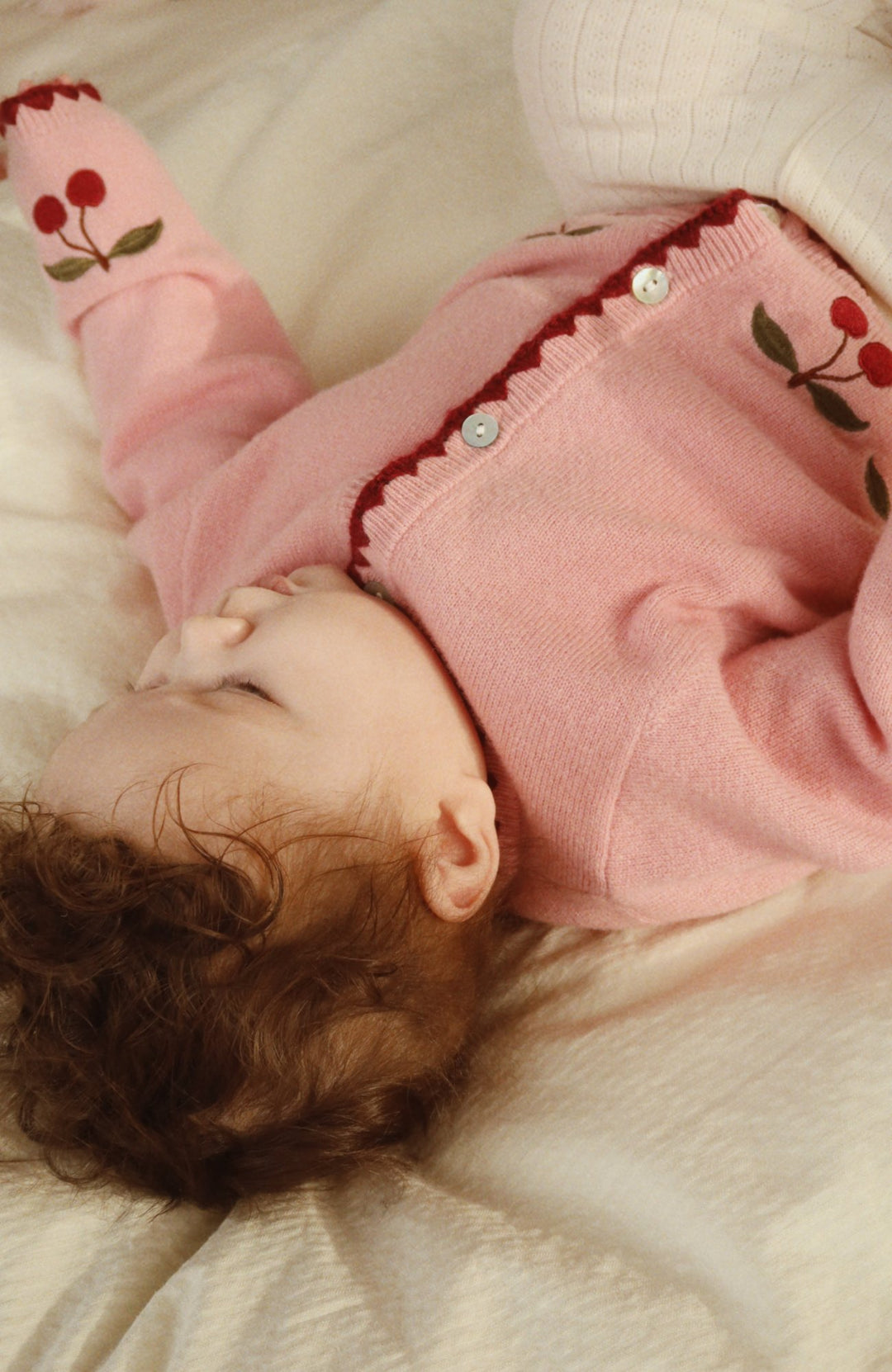 Bebis som ligger i Collette Cardigan i Pale Blush