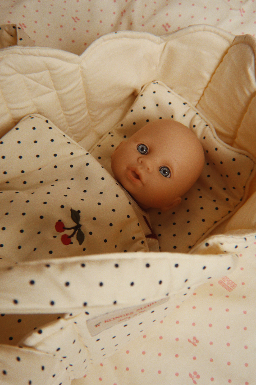 Babydockan Bella från Konges Slöjd nedbäddad i en dockvagn